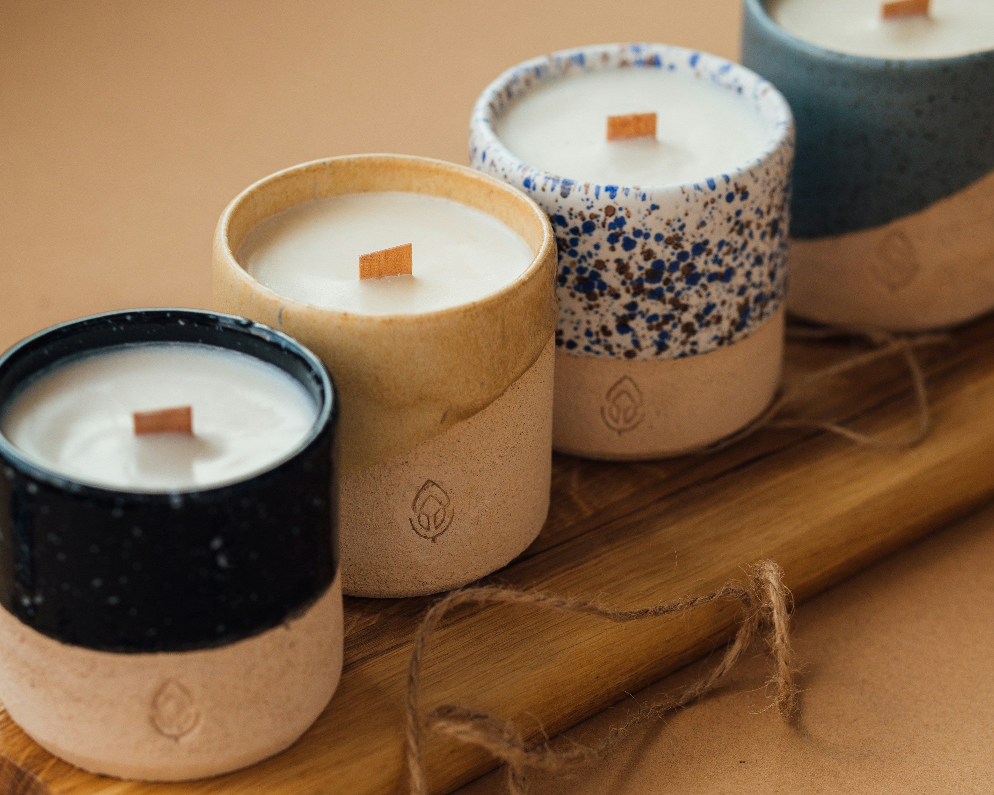 Set of candles in ceramic containers on a wooden board 