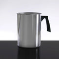 Stainless steel pitcher with a black handle on a reflective surface